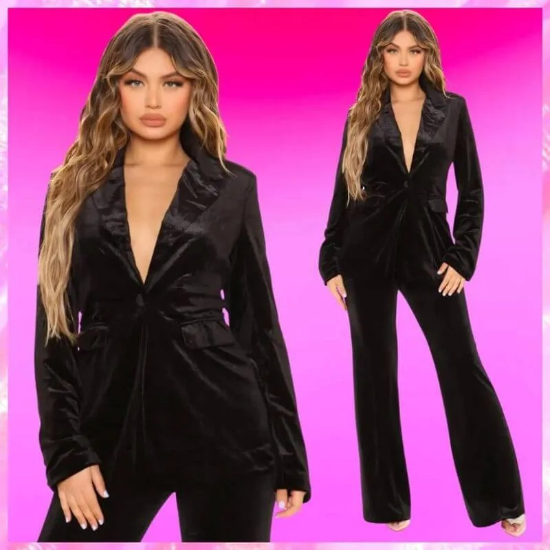 Model wearing a black velvet blazer and pant set with a deep V-neckline and flared pants.