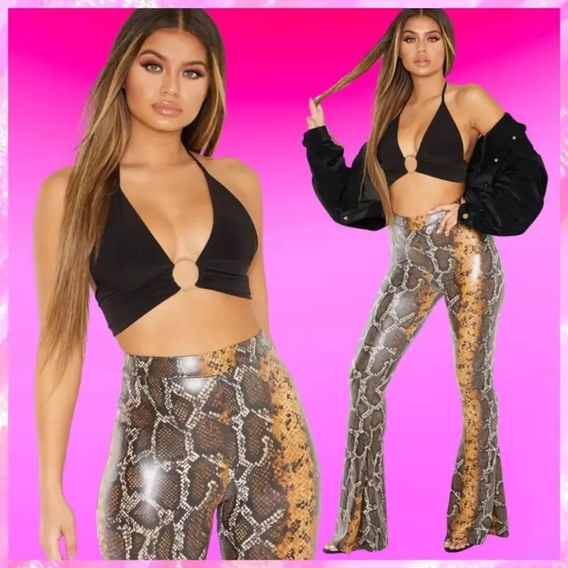 Model wearing a black halter top with a circular cutout and snake print flared pants against a pink background.